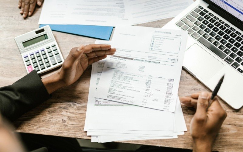 Pakistani passport, euro banknotes, calculator, bank statement, and Schengen visa travel cost documents.
Copy alt text